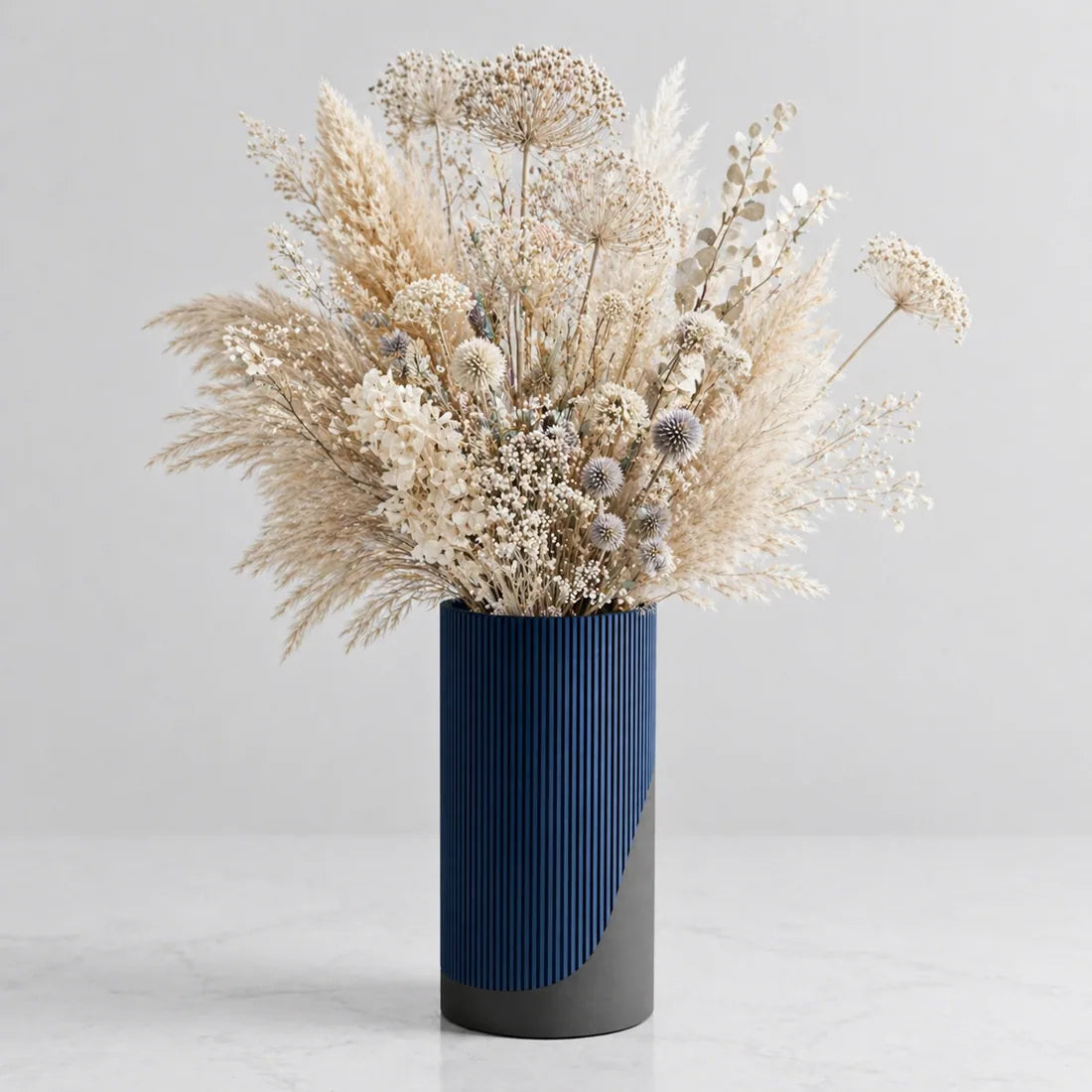 Dried floral arrangement in blue ribbed vase