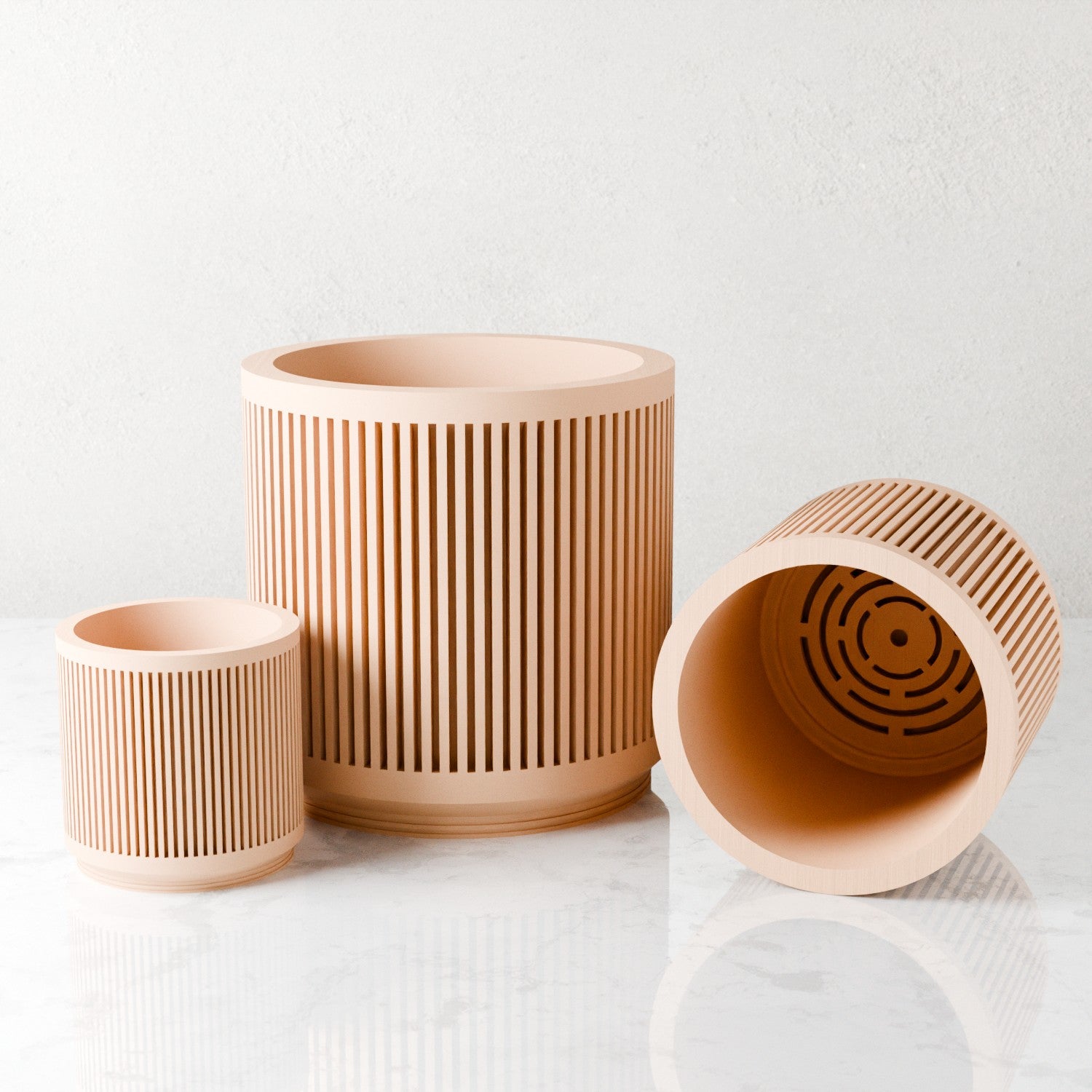 Three peach Kanso planters with one tipped to show interior drainage