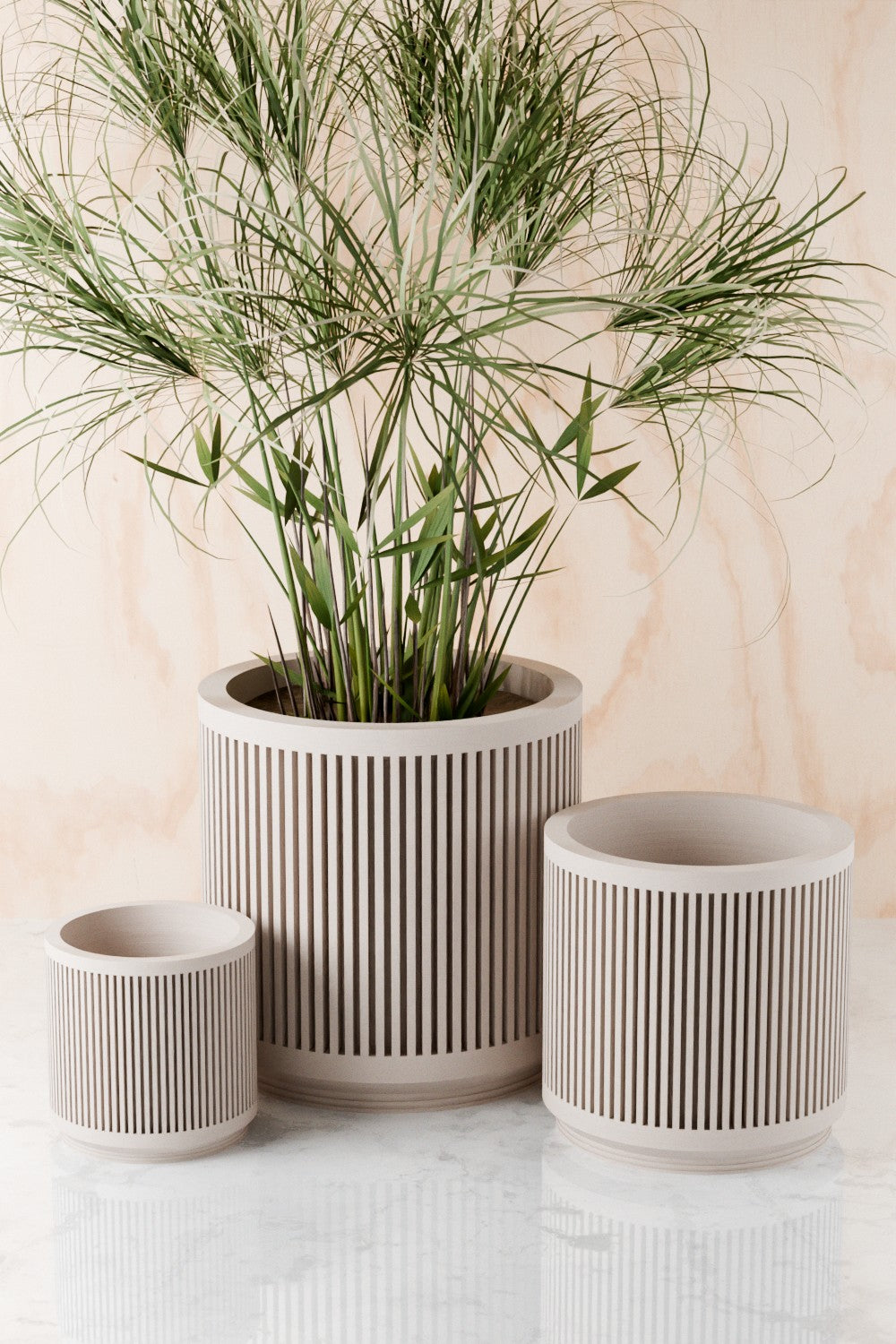 Three off-white Kanso fluted planters in graduated sizes with a palm plant