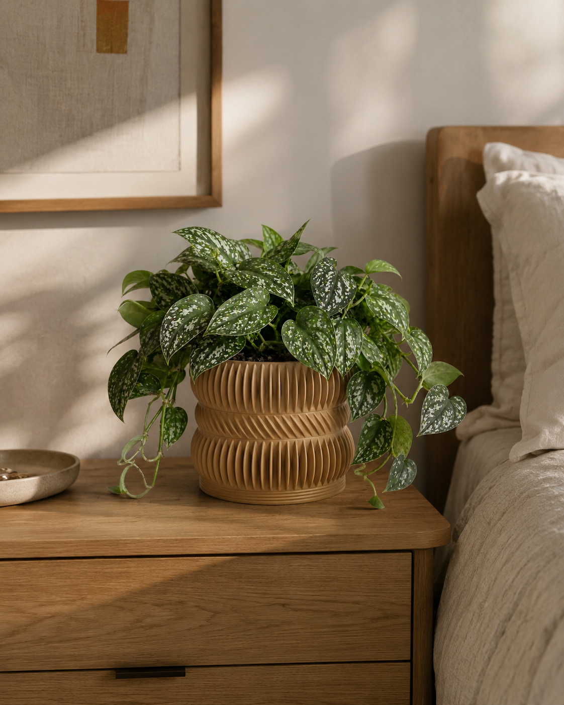 Trailing houseplant in tan ribbed planter on a nightstand